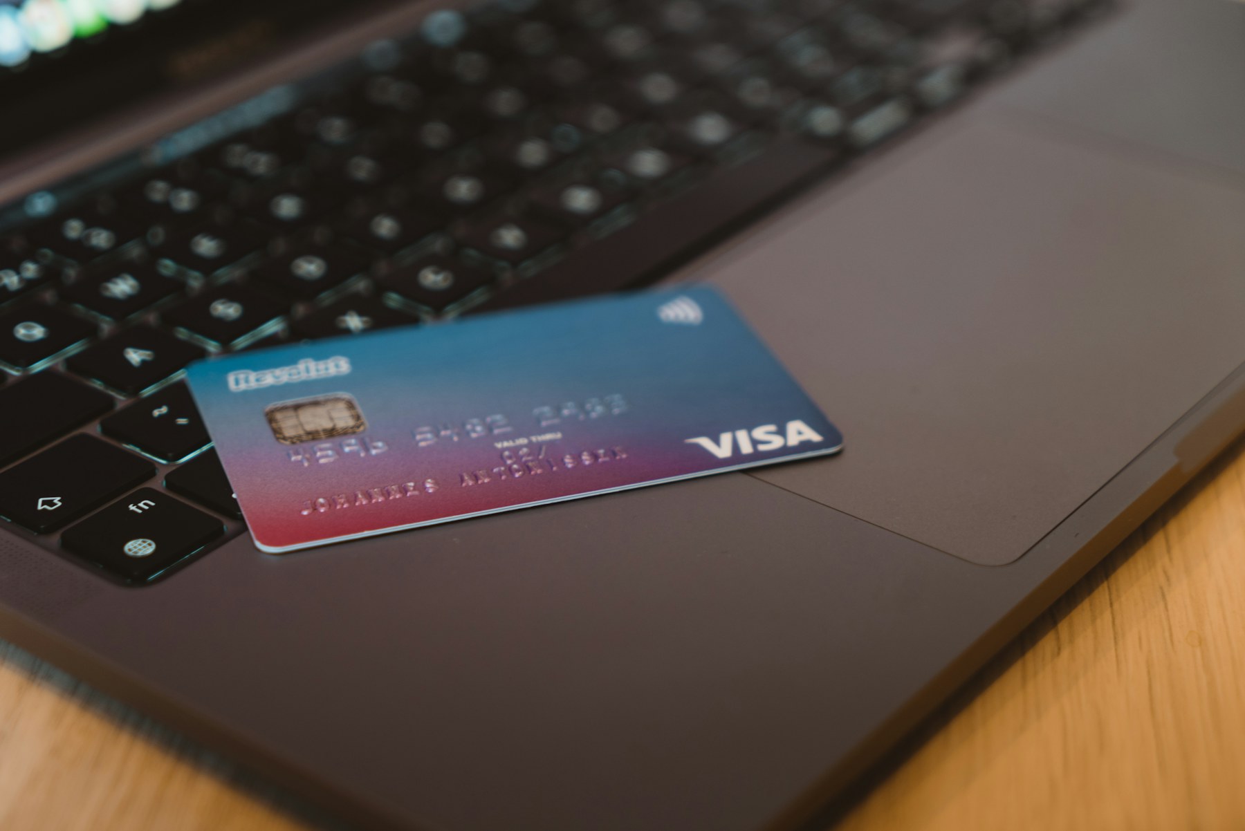 Банковская карта Visa на клавиатуре ноутбука — оплата зарубежных сервисов
